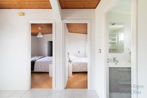 a white bathroom with two beds and a sink at A Casa de Carmen in Cangas de Morrazo