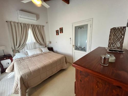a bedroom with a bed and a dresser and a window at Entre Sierras VGB Bertone in Villa General Belgrano
