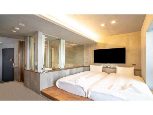 a bedroom with two beds and a flat screen tv at Hotel Discover Nagaokakyo - Vacation STAY 34376v in Nagaokakyo