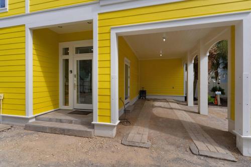 a yellow house with white doors and a porch at A Point of View in Seagrove Beach