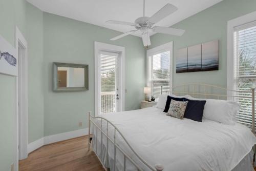 a bedroom with a white bed with a ceiling fan at A Point of View in Seagrove Beach