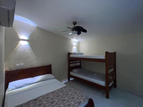 a bedroom with two bunk beds and a ceiling fan at Hotel Bahia Plaza in Santa Marta