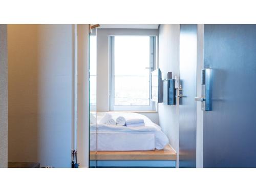 a bedroom with a bed and a window at Hotel Discover Nagaokakyo - Vacation STAY 34433v in Nagaokakyo