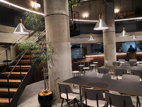 a restaurant with tables and chairs and a staircase at Hotel Discover Nagaokakyo - Vacation STAY 34433v in Nagaokakyo