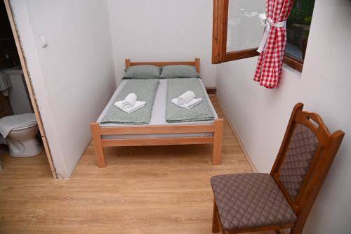 a small bed in a room with a chair at Konak Dobri Potok in Krupanj