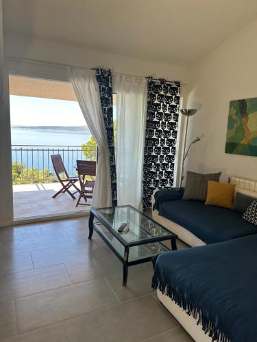 Villa Amari في بريلا: غرفة معيشة مع أريكة وطاولة زجاجية