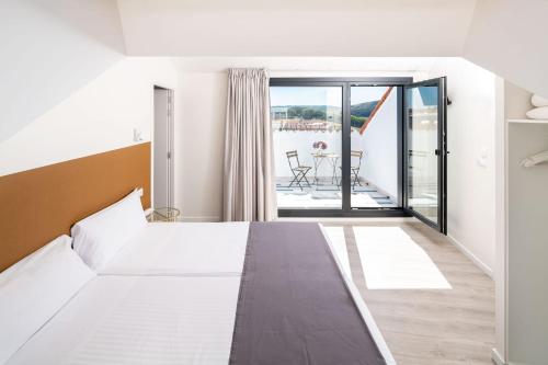 a hotel room with a bed and a balcony at Hotel Concheiros in Santiago de Compostela