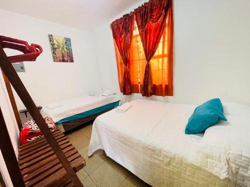 een slaapkamer met 2 bedden en een raam bij Apartamentos Jasmin in San Pedro La Laguna