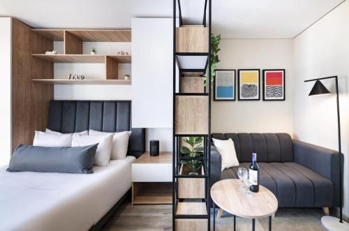 um quarto com uma cama, um sofá e uma mesa em gA Estupendo loft en Cabrera em Bogotá