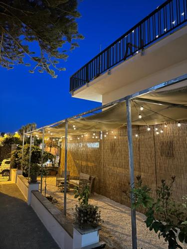 eine Terrasse mit einem Zaun und ein Gebäude mit Beleuchtung in der Unterkunft Terrazza Levante in Otranto