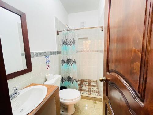 y baño con aseo, lavabo y ducha. en Apartamentos Jasmin, en San Pedro La Laguna