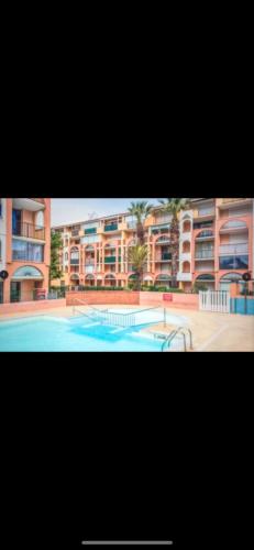 une grande piscine devant un immeuble dans l'établissement Le paradis du cap, au Cap d'Agde