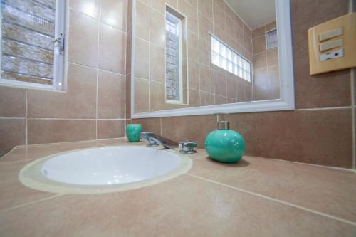 a bathroom sink with a blue vase on it at Hotel Casa Rush in Puerto Ángel