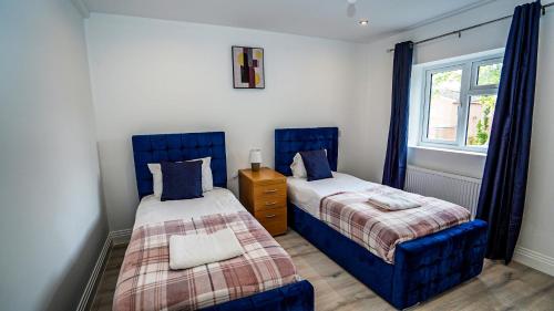 1 Schlafzimmer mit 2 Betten und einem Fenster in der Unterkunft 4-Bedroom, 3-Bath Home Sleeps 8 Free Parking in Farnham Royal