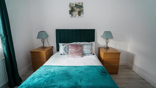 ein Schlafzimmer mit einem Bett mit zwei Nachttischen in der Unterkunft 4-Bedroom, 3-Bath Home Sleeps 8 Free Parking in Farnham Royal