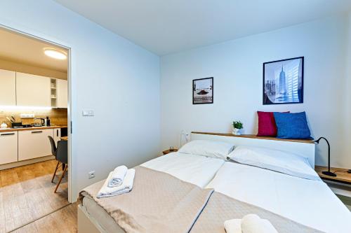 een slaapkamer met een groot wit bed en een keuken bij Rezidence Mozart in Praag
