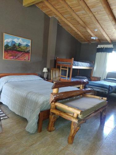 a bedroom with a bed and a bench in it at Departamento Uspallata in Uspallata