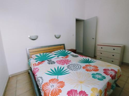 1 Schlafzimmer mit einem Bett mit Blumenbettdecke in der Unterkunft Le cocotier in Les Trois-Îlets