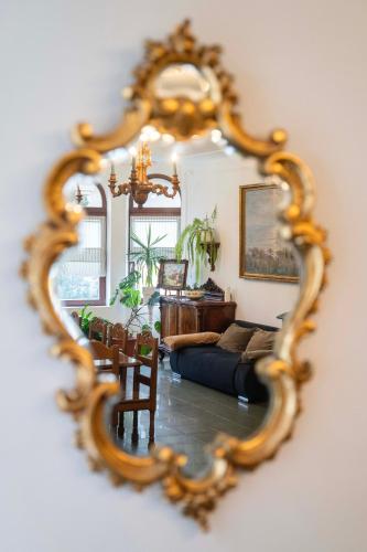 a mirror reflecting a living room with a couch at Villart vendégház in Keszthely