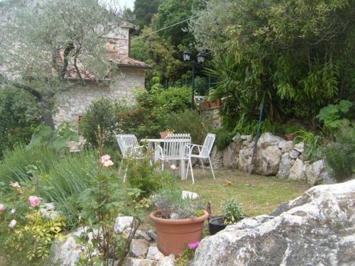 a garden with a table and chairs and flowers at B&b La Casa Del Sole in Borgaria