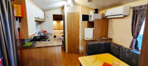 una piccola cucina con tavolo in un piccolo appartamento di MareBlue Mobilhomes & Caravans a Lido di Spina