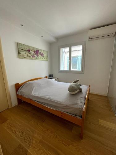 une chambre avec un lit dans une pièce avec une fenêtre dans l'établissement Plaisir côtier Coeur de Bandol T3, Clim, 50m mer, à Bandol