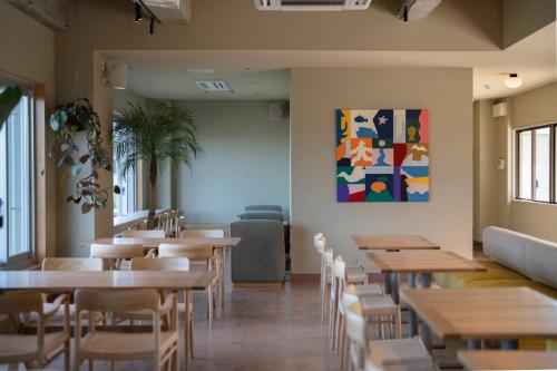 a restaurant with tables and chairs and a painting on the wall at HOTEL FARO manazuru - Vacation STAY 56476v in Manazuru