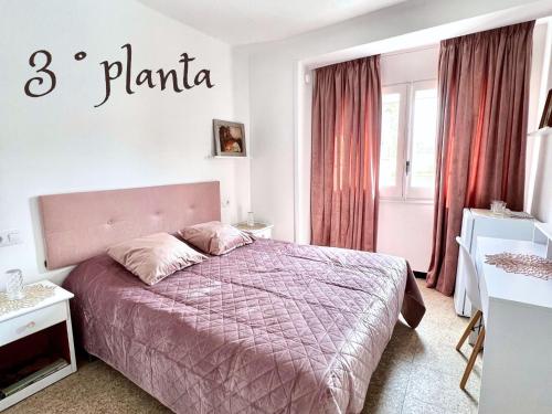 een slaapkamer met een bed met een paarse deken bij Escondite central con terraza compartida en la azotea y cocina compartida in Roses