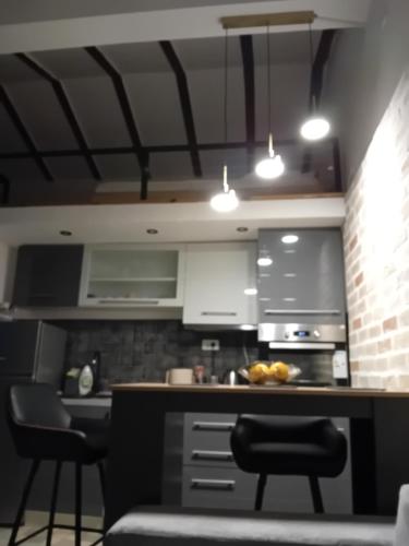a kitchen with a counter and two stools in it at Budva stan Natasa in Budva