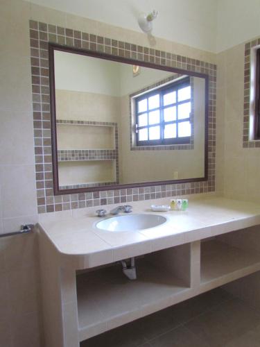 a bathroom with a sink and a large mirror at Hotel Casa Rush in Puerto Ángel
