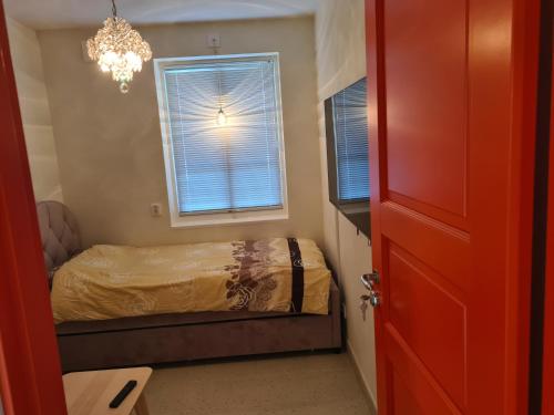Schlafzimmer mit einem Bett und einem Fenster mit einem Kronleuchter in der Unterkunft Ballet Villan in Kolmården