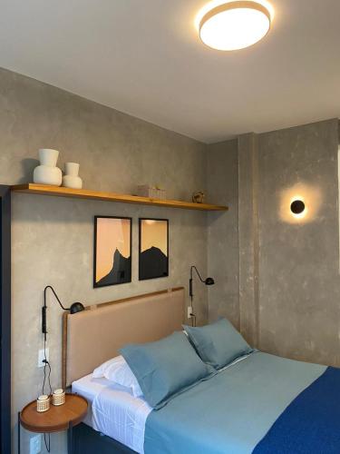 1 dormitorio con 1 cama con almohadas azules en Copa Hype Studio, en Río de Janeiro