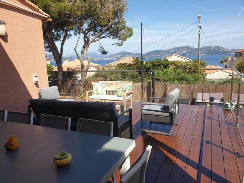 um pátio com uma mesa e cadeiras num deque em Superbe Villa avec piscine - vue mer - Presqu'Île de Giens - 5 étoiles em Hyères