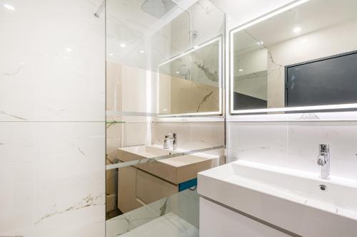 a white bathroom with a sink and a mirror at Appart Joli, Calme et Proche de Paris in Villejuif