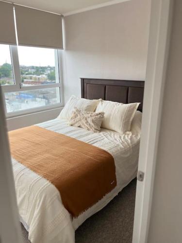 a bedroom with a bed with a large window at Departamento Nuevo con la comodidad que necesitas in Temuco