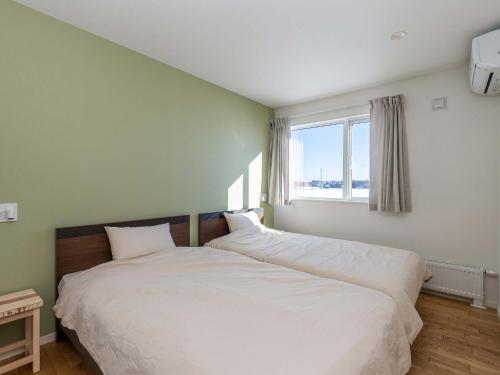 - une chambre avec un grand lit blanc et une fenêtre dans l'établissement Buena Vista Tokachi - Vacation STAY 47319v, à Obihiro