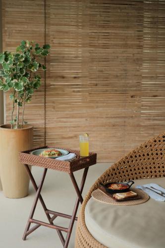 Schönhouse Villa Siargao في جنرال لونا: طاولة عليها طبق طعام وكأس عصير برتقال