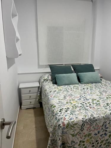 a bedroom with a bed with blue pillows at Novo Atlantico Golf 7 in Novo Sancti Petri