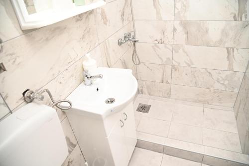 a white bathroom with a toilet and a sink at Konak Dobri Potok in Krupanj