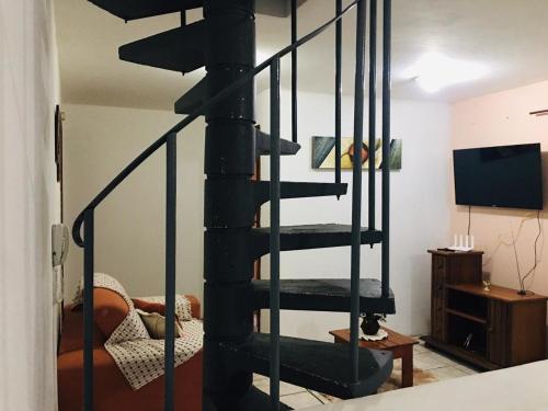 een zwarte wenteltrap in een woonkamer bij Apto Duplex confortável a apenas 2 km do Capivari in Campos do Jordão