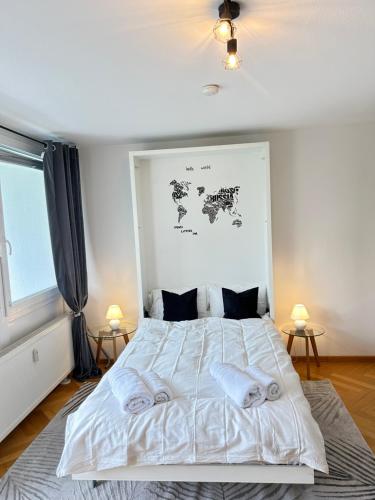 a bedroom with a large white bed with two lamps at Stilvolles Apartment - Unteraching in Unterhaching