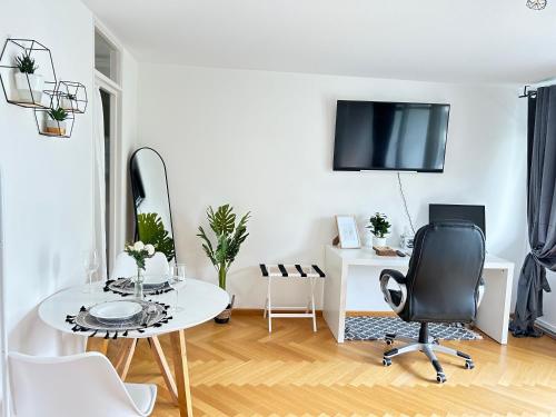 a white living room with a table and a chair at Stilvolles Apartment - Unteraching in Unterhaching