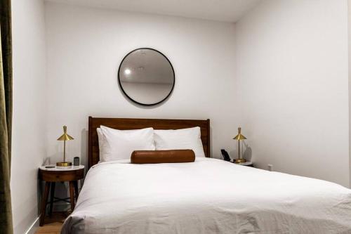 a bedroom with a white bed with a mirror on the wall at DTWN Historic Hotel, The Phenix, Ground Floor, Room # 100 in Bangor