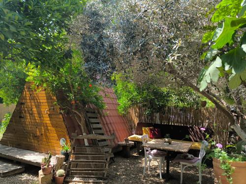 un jardín con una mesa de madera y un árbol en Litost Cafe Bungalow en Adrasan