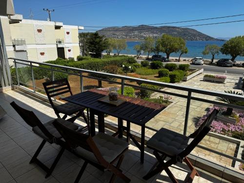 a table and chairs on a balcony with a view at Seashore Happiness Apartments in Porto Rafti