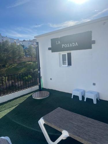 a room with a table and two benches on a balcony at La Posada in Setenil
