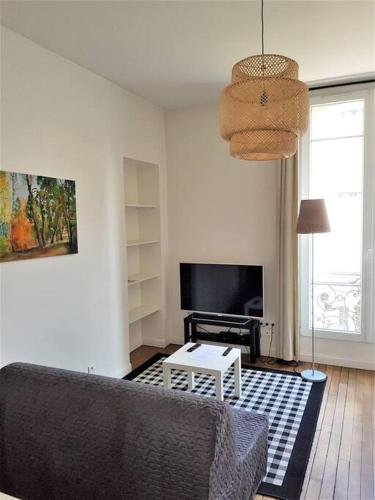 een woonkamer met een bank en een tafel bij Le Cours Langlet B in Reims