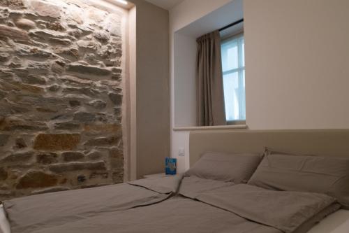 łóżko w pokoju z kamienną ścianą w obiekcie API Tenna Apartments Glicine 1 w mieście Tenna 