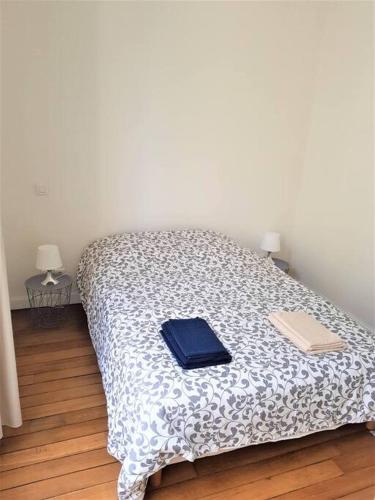 une chambre avec un lit avec deux livres dessus dans l'établissement Le Cours Langlet B, à Reims