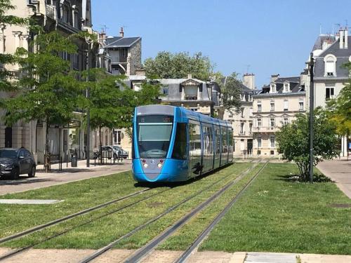 een blauwe trein op de rails in een stad bij Le Cours Langlet B in Reims